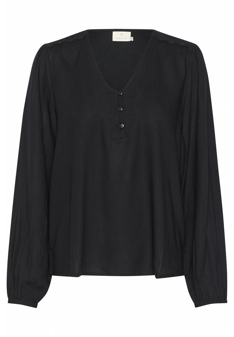 Schwarze Bluse mit langen Ärmeln aus leichtem Stoff. Sie hat einen V-Ausschnitt, drei Knöpfe und zarte Details an der Schulter.