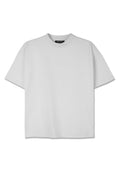 Weißes, übergroßes T-Shirt mit Rundhalsausschnitt, kurzen Ärmeln und einem dezenten geprägten Logo auf der Vorderseite. Hergestellt aus weichem Jersey-Material.