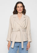 Beige Wickeljacke aus weichem Stoff, mit einem Taillengürtel, breiten Revers und langen Ärmeln. Mit einer subtilen Textur.