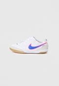 Weißer Sportschuh mit glattem Obermaterial, versehen mit einem blauen und pinken Nike-Logo, grauen Akzenten und einer Laufsohle aus Naturkautschuk.