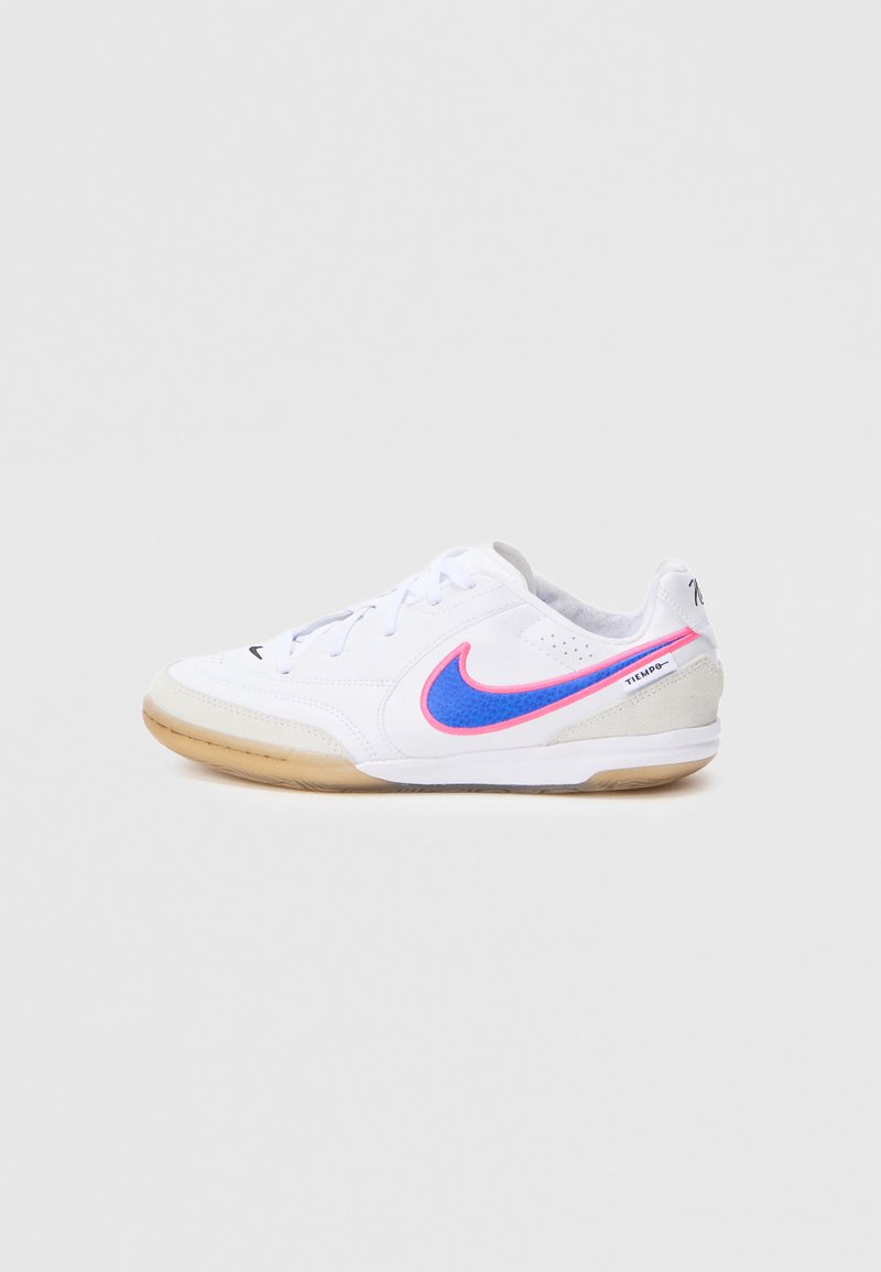 Weißer Sportschuh mit glattem Obermaterial, versehen mit einem blauen und pinken Nike-Logo, grauen Akzenten und einer Laufsohle aus Naturkautschuk.