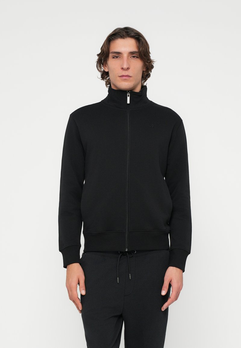 Schwarzer Sweatshirt mit Reißverschluss, hohem Kragen, langen Ärmeln, gerippten Bündchen und Bund. Verfügt über ein kleines Logo auf der Brust. Weiches Material.