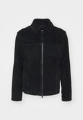 Schwarze Wildlederjacke mit einem Reißverschluss vorne, kragenlosem Ausschnitt und horizontalen Fransen über der Brust. Lange Ärmel mit umgeschlagenen Enden.