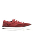 Niedrig geschnittene rote Canvas-Sneaker mit weißen Schnürsenkeln, weißer Sohle und schwarzen Streifendetails, seitlich auf einem weißen Hintergrund dargestellt.