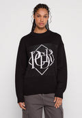 Schwarzer Strickpullover mit einem großen weißen Grafikdesign auf der Vorderseite, das Buchstaben und Formen umfasst, sowie gerippten Bündchen und Saum.