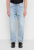 Mann trägt hellblaue Straight-Leg-Jeans mit leichter Abnutzung am Knie, schwarze Lederschnallenschuhe und ein schwarzes, eingestecktes Hemd.