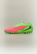 Helles Pink und Neon-Grün Fußballschuh mit schwarzem Nike-Swoosh und strukturiertem Sohlenprofil für Kunstrasen, seitlich auf neutralem Hintergrund dargestellt.