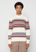 Cremfarbener Strickpullover mit geometrischen Mustern in Rot, Marineblau und Braun, mit Rundhalsausschnitt und langen Ärmeln.