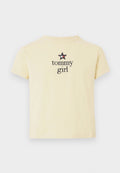 Gelbes Baumwoll-T-Shirt mit Rundhalsausschnitt und kurzen Ärmeln, das ein schwarzes Sternenmotiv über dem Text "tommy girl" in fetter Schrift zeigt.