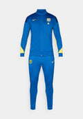 Blauer Nike-Trainingsanzug mit gelben Akzenten, bestehend aus einer Jacke mit Reißverschluss und passenden, schmal geschnittenen Hosen. Mit Team-Logo auf Brust und Oberschenkel.
