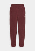 Bordeauxfarbene Fleece-Sweatpants mit einem elastischen Bund und einem weißen Nike-Logo auf dem linken Oberschenkel. Schmal zulaufende Beine mit einer glatten Textur.