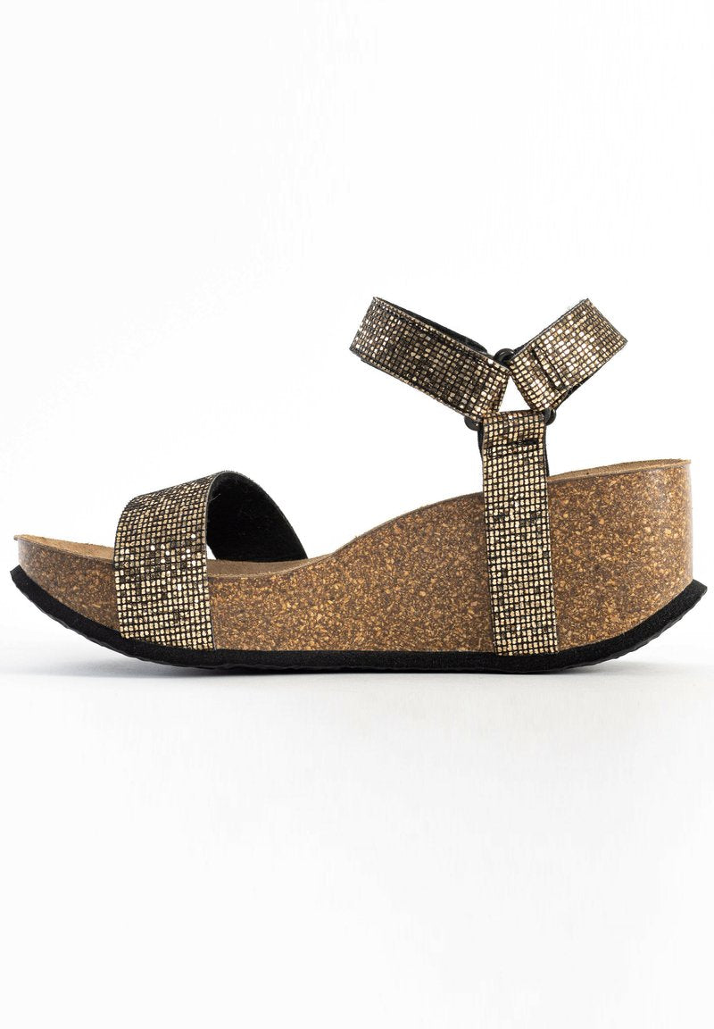 Keilsohle mit Korksohle und metallic-gittermusterartigen Riemen, mit Bändern für Knöchel und Zehen, vor einem weißen Hintergrund.