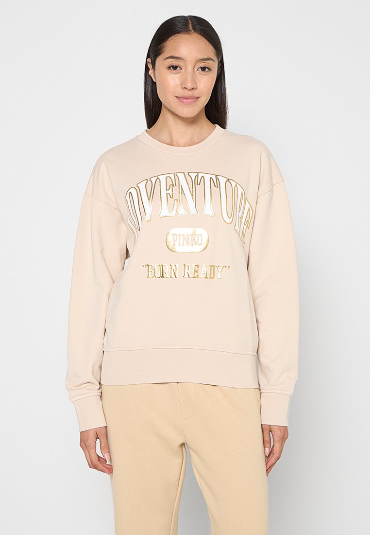 Beiges Sweatshirt mit Rundhalsausschnitt, versehen mit goldener Schrift "ADVENTURE PINKO 'BORN READY'" und gerippten Bündchen. Etwas oversized geschnitten.