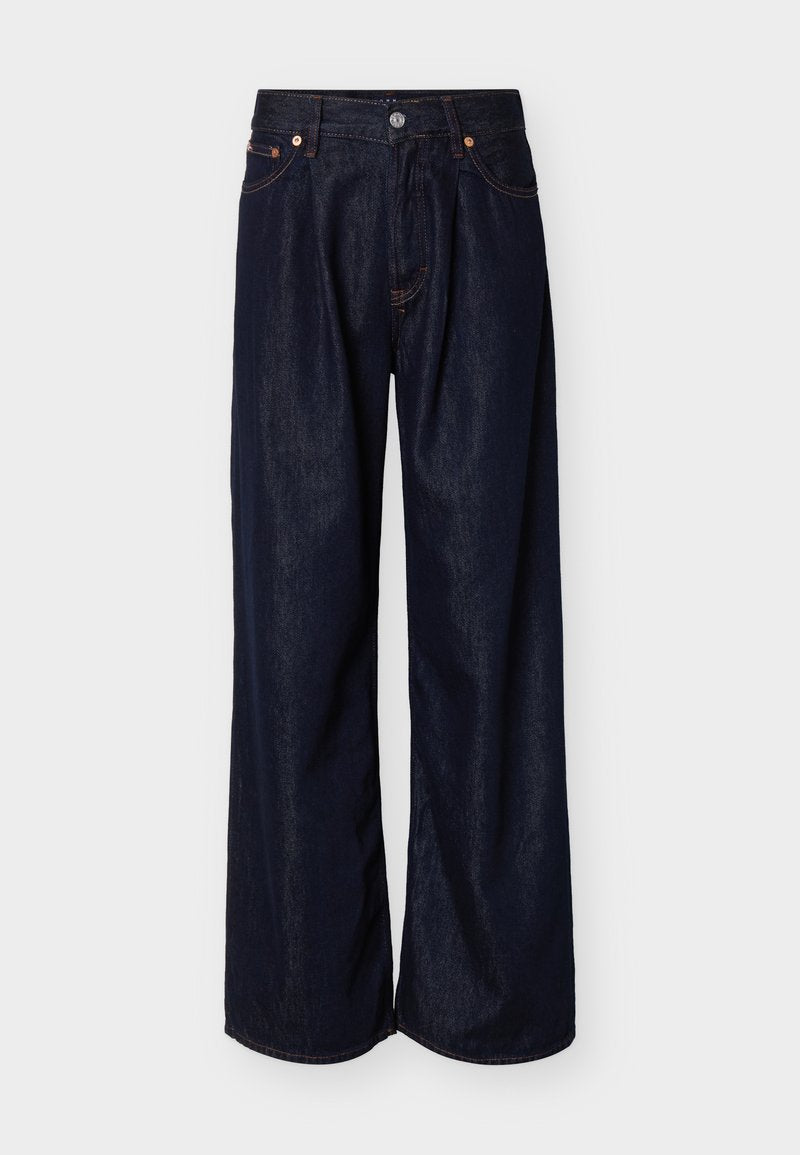 Weit geschnittene dunkelblaue Jeans aus Denim mit Frontknopf und Fünf-Taschen-Design vor einem schlichten hellen Hintergrund.
