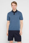 Geripptes Kurzarm-Poloshirt in Blau mit schwarzem Kragen und Zierleisten. Bequeme Passform mit strukturierter Stoffoberfläche und Logodetail am Saum.