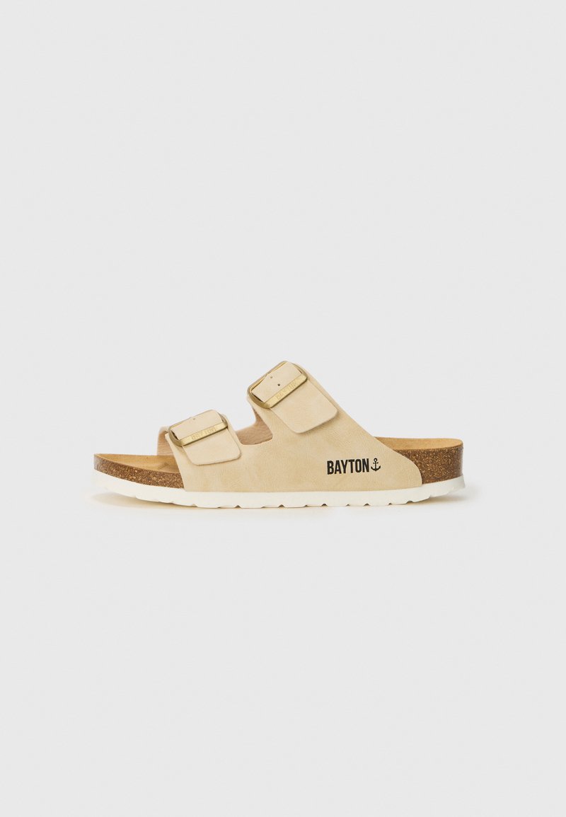 Beige Slippers mit zwei verstellbaren Riemen, goldfarbenen Schnallen und Korksohle. Verfügt über eine strukturierte Außensohle und den Markennamen seitlich aufgedruckt.