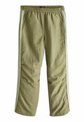 Olivegrüne, leichte Hose mit elastischem Bund und seitlichen Streifen in einem helleren Grün. Verfügt über zwei Taschen und eine lockere Passform.