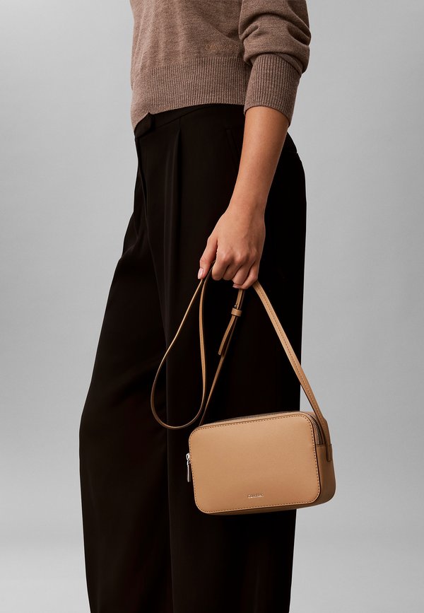 Calvin Klein FOIL LOGO ELONGATED CAMERA - Cross body bag - tannin