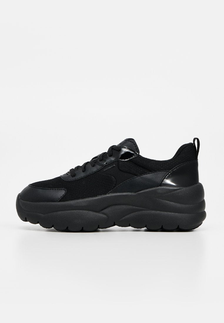 Schwarzer klobiger Sneaker mit dicker Sohle, Mesh- und Lederobermaterial, Schnürung vorne und Zuglasche an der Ferse, im Seitenprofil auf weißem Hintergrund gezeigt.
