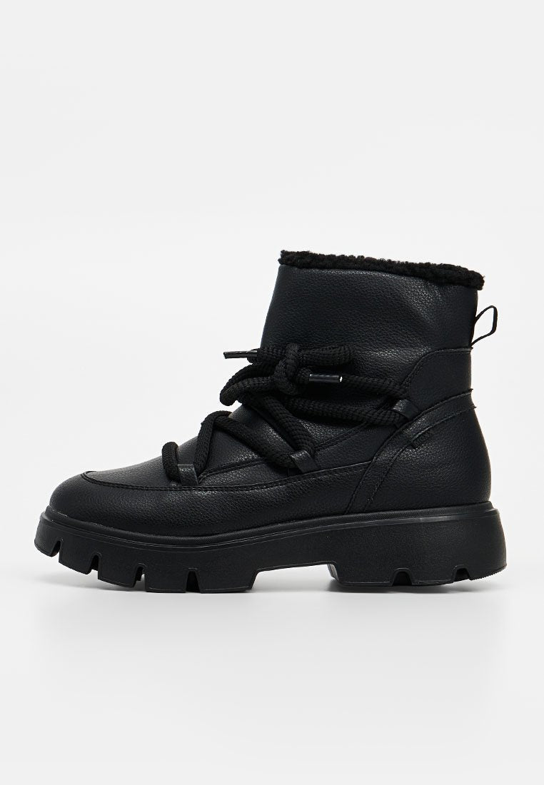 Schwarzer Knöchelstiefel mit dicker Sohle, gepolstertem Obermaterial, breiten Schnürsenkeln, die zu einer Schleife gebunden sind, und einer Zuglasche hinten.