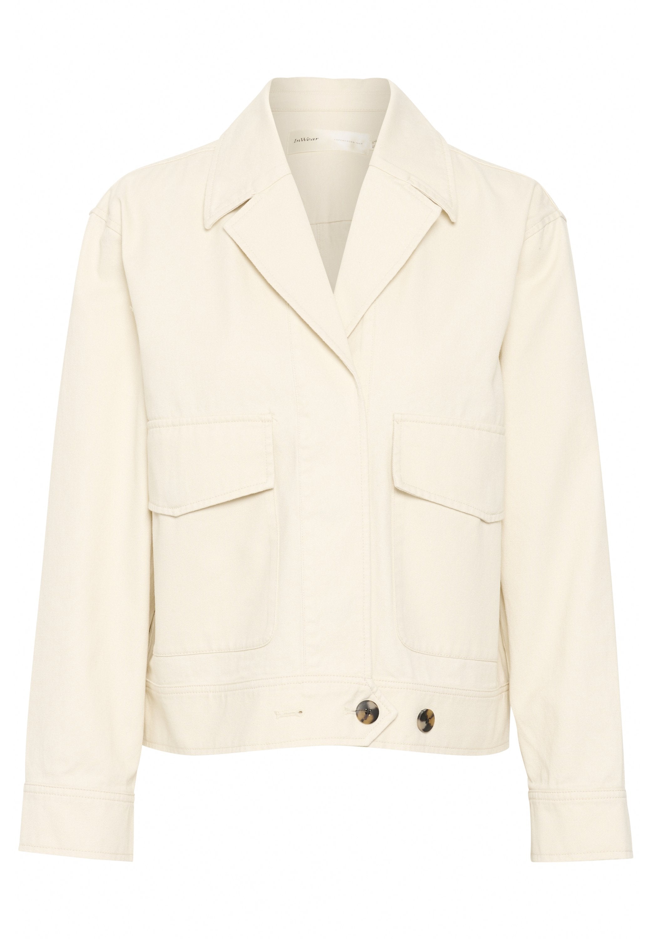 Cremfarbener Blazer mit geknöpftem Kragen, zwei vorderen Taschen und zwei runden Knöpfen in der Taille. Hergestellt aus glattem Stoff, strukturiertes Design.