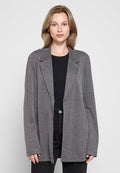 Grau karierter Blazer mit langen Ärmeln, Reverskragen und lässiger Passform, getragen über einem schwarzen Oberteil und kombiniert mit dunkler Jeans.