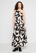 Maxikleid mit einseitigem Design, das einen beigen Hintergrund und kräftige schwarze abstrakte Muster aufweist. Aus leichter Stoffqualität mit lockerer Passform.
