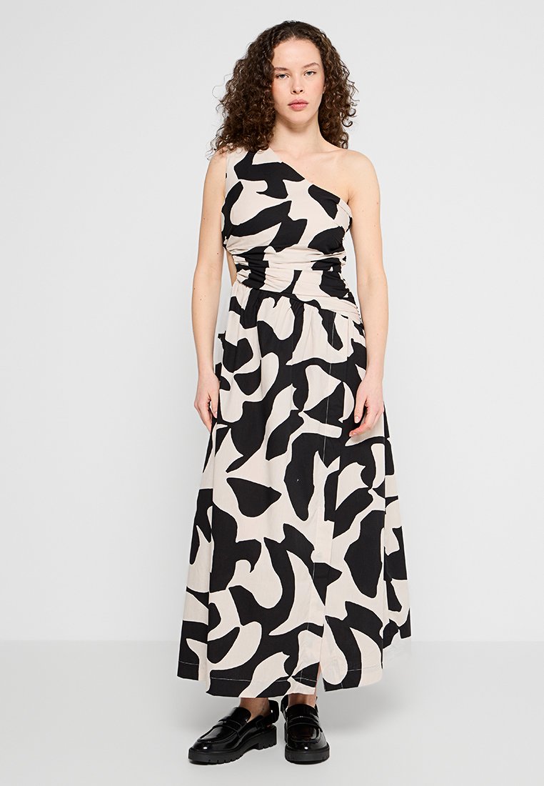 Maxikleid mit einseitigem Design, das einen beigen Hintergrund und kräftige schwarze abstrakte Muster aufweist. Aus leichter Stoffqualität mit lockerer Passform.