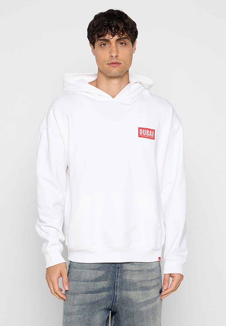 Weißer Hoodie mit einer Fronttasche und einem roten "DUBAI"-Logo auf der linken Brust. Lange Ärmel und eine Kordelzugkapuze runden das Design ab.