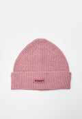 Weiche rosa gerippte Strickmütze mit umgeschlagenem Bündchen und rechteckigem Etikett mit schwarzem Schriftzug "PINKO" auf rosa Hintergrund.