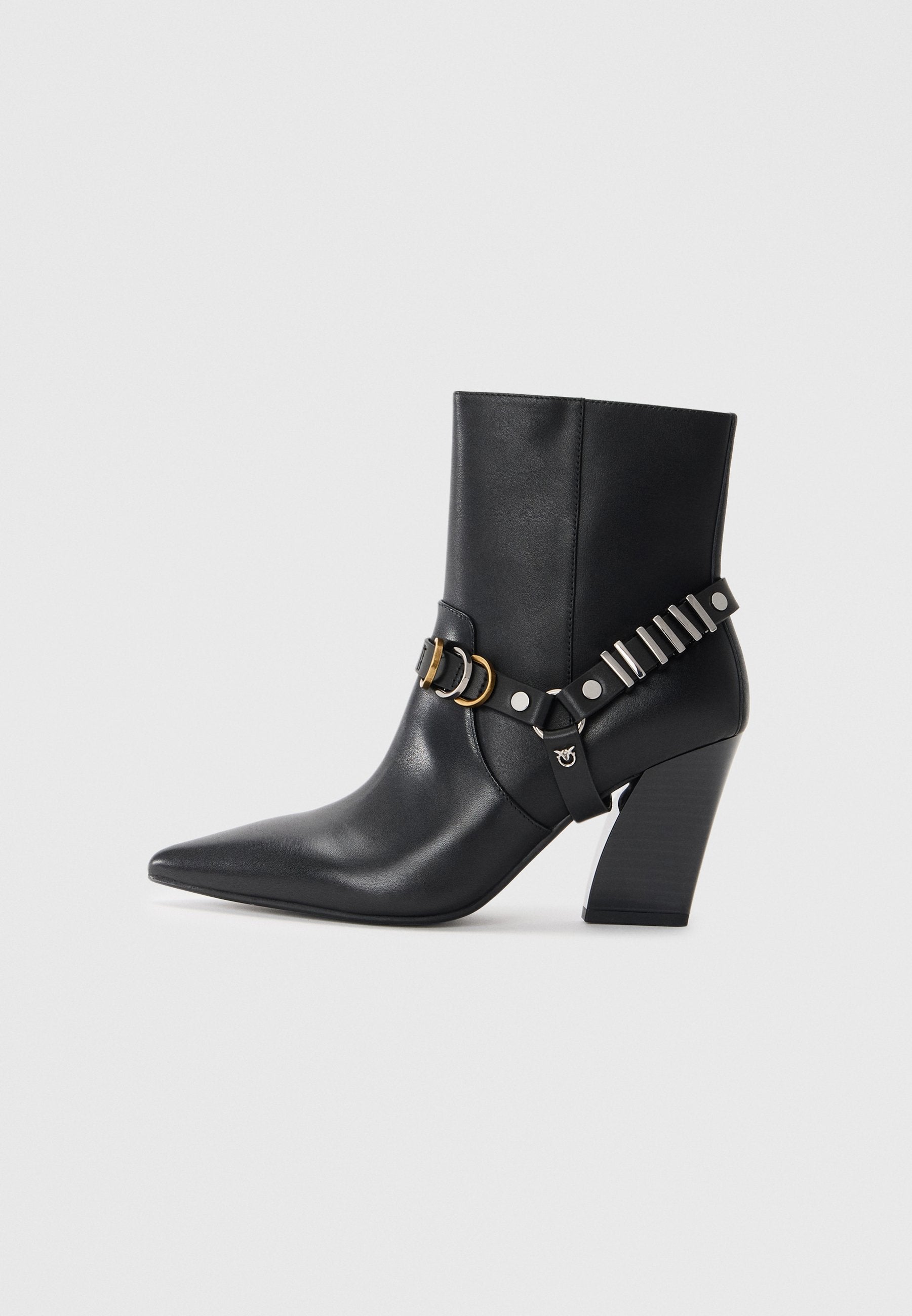 Schwarze Leder-Ankle-Boots mit spitzem Zehenbereich, gestapeltem Absatz und dekorativem Riemen mit Metallbeschlägen und Nieten. Glatte Textur.