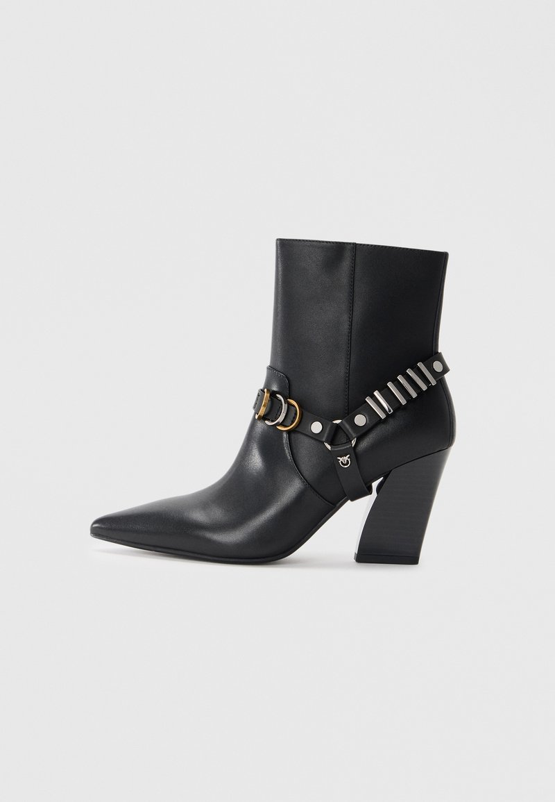 Schwarze Leder-Ankle-Boots mit spitzem Zehenbereich, gestapeltem Absatz und dekorativem Riemen mit Metallbeschlägen und Nieten. Glatte Textur.