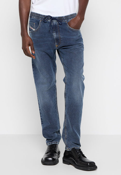 Blaue Jeanshose mit elastischem Bund, Kordelzug und seitlichen Taschen. Der Stoff hat eine leichte Waschung für eine interessante Textur.