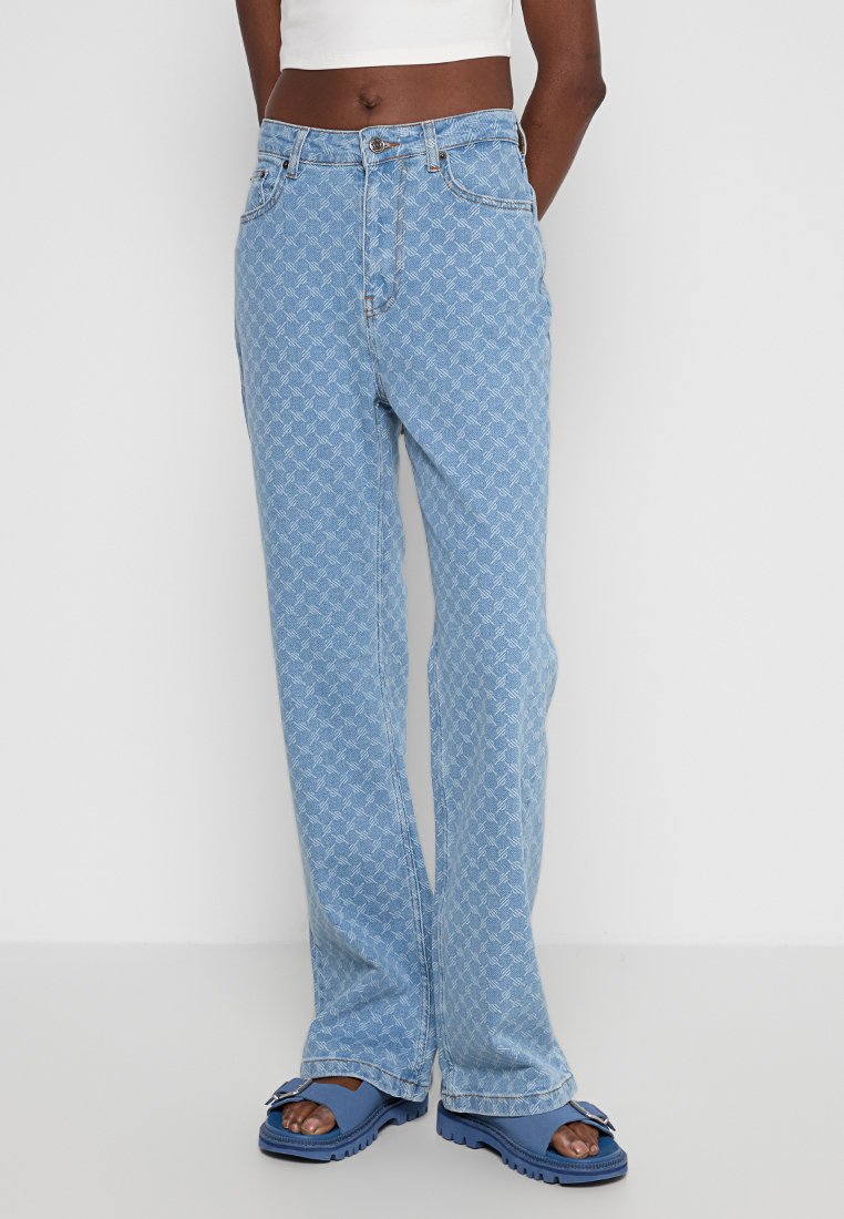 Hellblaue Jeans aus Denim mit einem durchgehenden weißen geometrischen Muster, geraden Beinen, fünf Taschen und mittelhoher Taille.