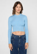 Hellblaues Crop-Top mit langen Ärmeln, gerippter Struktur und wiederholtem weißem Logo-Muster. Kombiniert mit hoch taillierten dunklen Jeans aus Denim.