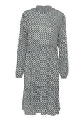 Langärmliges Kleid mit hohem Kragen, das ein geometrisches Schwarz-Weiß-Muster aufweist, einen elastischen Bund hat und im Design einen schichtenförmigen Rock besitzt.