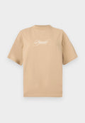 Beige Baumwoll-T-Shirt mit kurzen Ärmeln, rundem Halsausschnitt und weißem, geschwungenem Text auf der Vorderseite mit der Aufschrift "Pegador Dreams Come True."