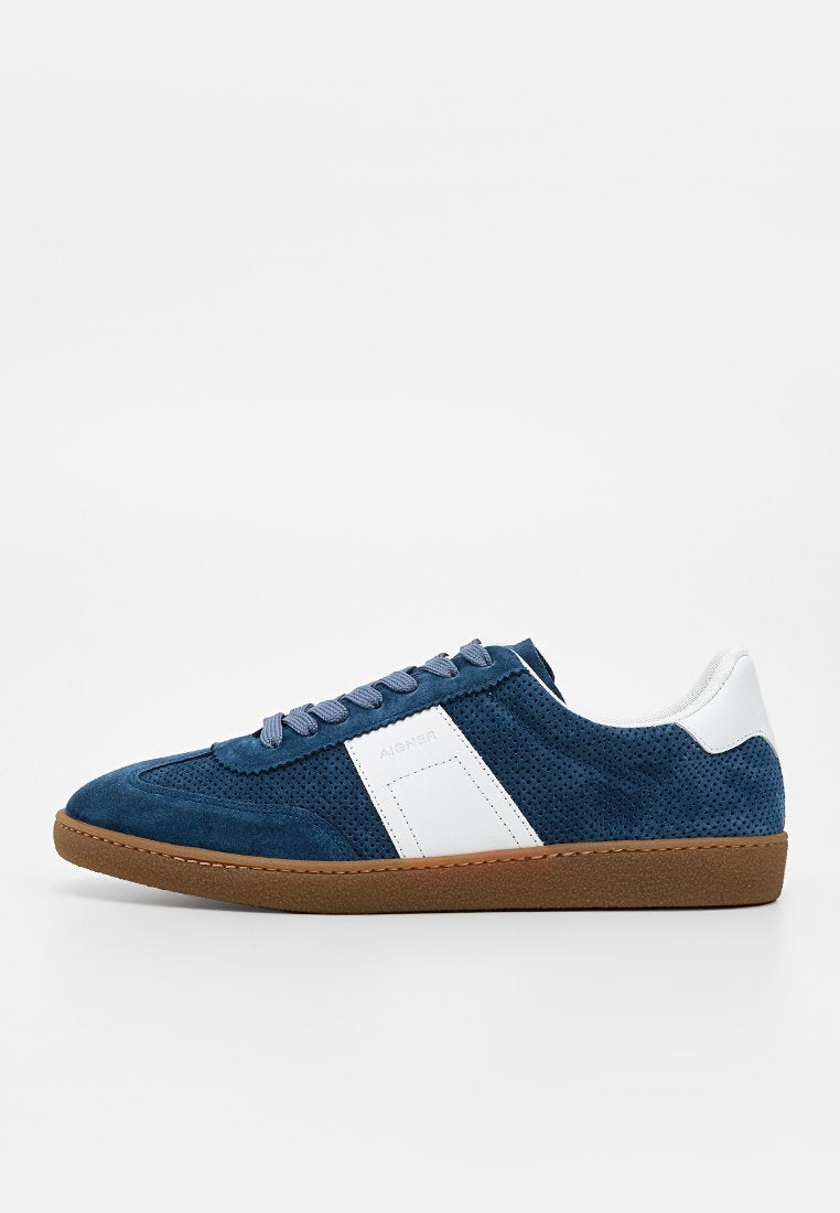 Blauer Wildleder-Sneaker mit niedrigem Schaft, Perforationen, weißem Seitenpaneel und Fersenschlaufe, brauner Gummisohle und Schnürverschluss auf weißem Hintergrund.