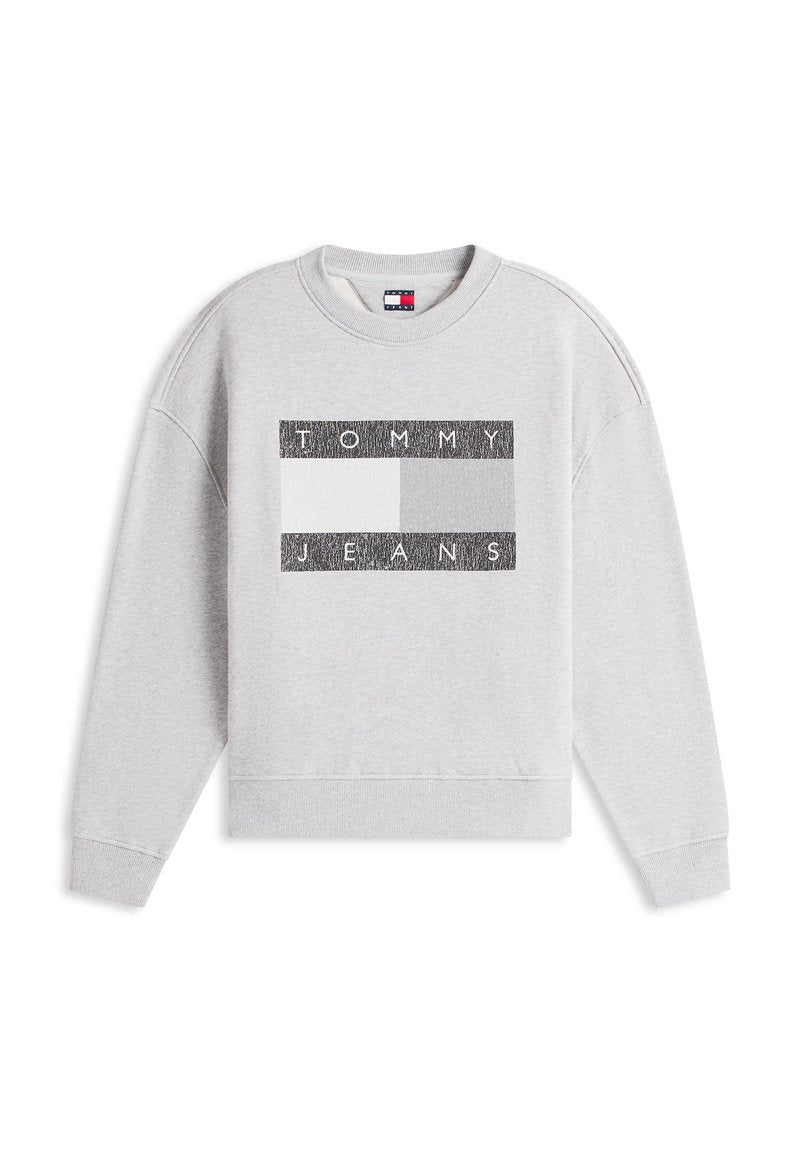 Grauer Sweatshirt mit langen Ärmeln und gerippten Bündchen. Mit einem rechteckigen schwarz-weißen Motiv mit dem Schriftzug "TOMMY JEANS" auf der Brust.