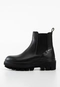 Schwarze Leder-Ankle Boots mit elastischen Seitenpaneelen, einer dicken Plateausohle und einem Ziehschlaufen an der Ferse für leichtes An- und Ausziehen.