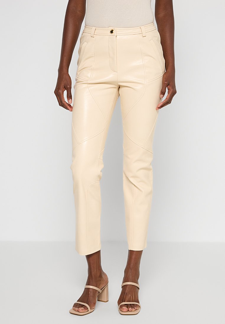 Beige Kunstlederhosen mit Slim Fit, ausgestattet mit ausgeprägten Nahtdetails und einem Reißverschluss mit Knopfverschluss.