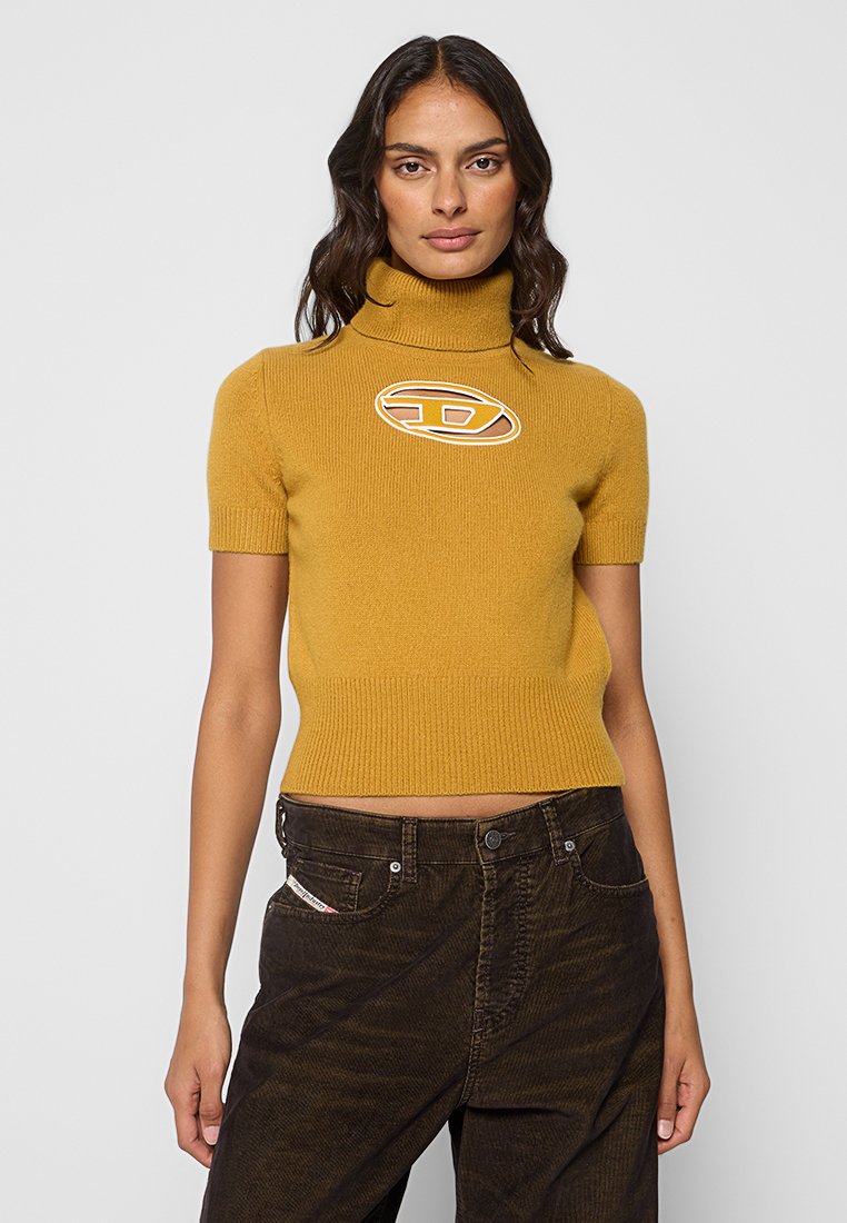 Kurzärmeliger, gerippter Rollkragenpullover in Senfgelb mit einem Logodetail auf der Brust. Weiche Textur und taillierte Passform.