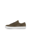 Olivgrüner Wildleder-Sneaker mit glatter Textur, weißer Gummisohle und rundem Zehenbereich. Verfügt über passende Ösen und flache Schnürsenkel.