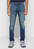 Schmal geschnittene Jeans aus Denim in mittlerer blauer Waschung mit verblassten Akzenten. Verfügt über fünf Taschen, Gürtelschlaufen und kontrastierende Nähte. Kombiniert mit silbernen Sportschuhen.