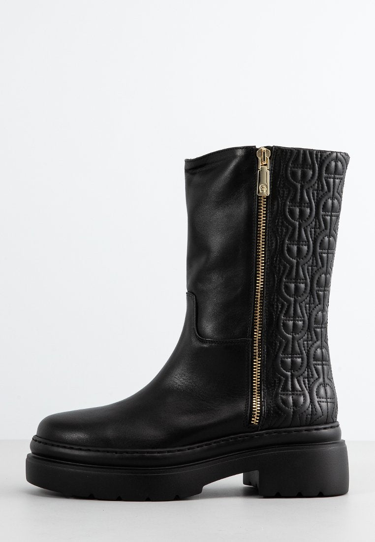 Schwarze Leder-Ankle-Boots mit glattem Vorderteil und gestepptem Muster an der Seite, ausgestattet mit einem goldenen Reißverschluss und einer massiven schwarzen Laufsohle.