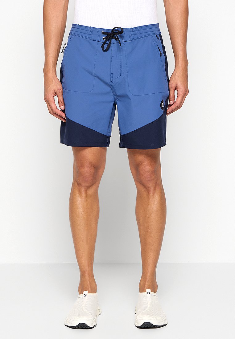 Blaue Schwimmshorts mit navyfarbenen Akzenten, ausgestattet mit einem Kordelzugbund, zwei Taschen und einem Logo an der Seite. Das Material ist leicht und trocknet schnell.