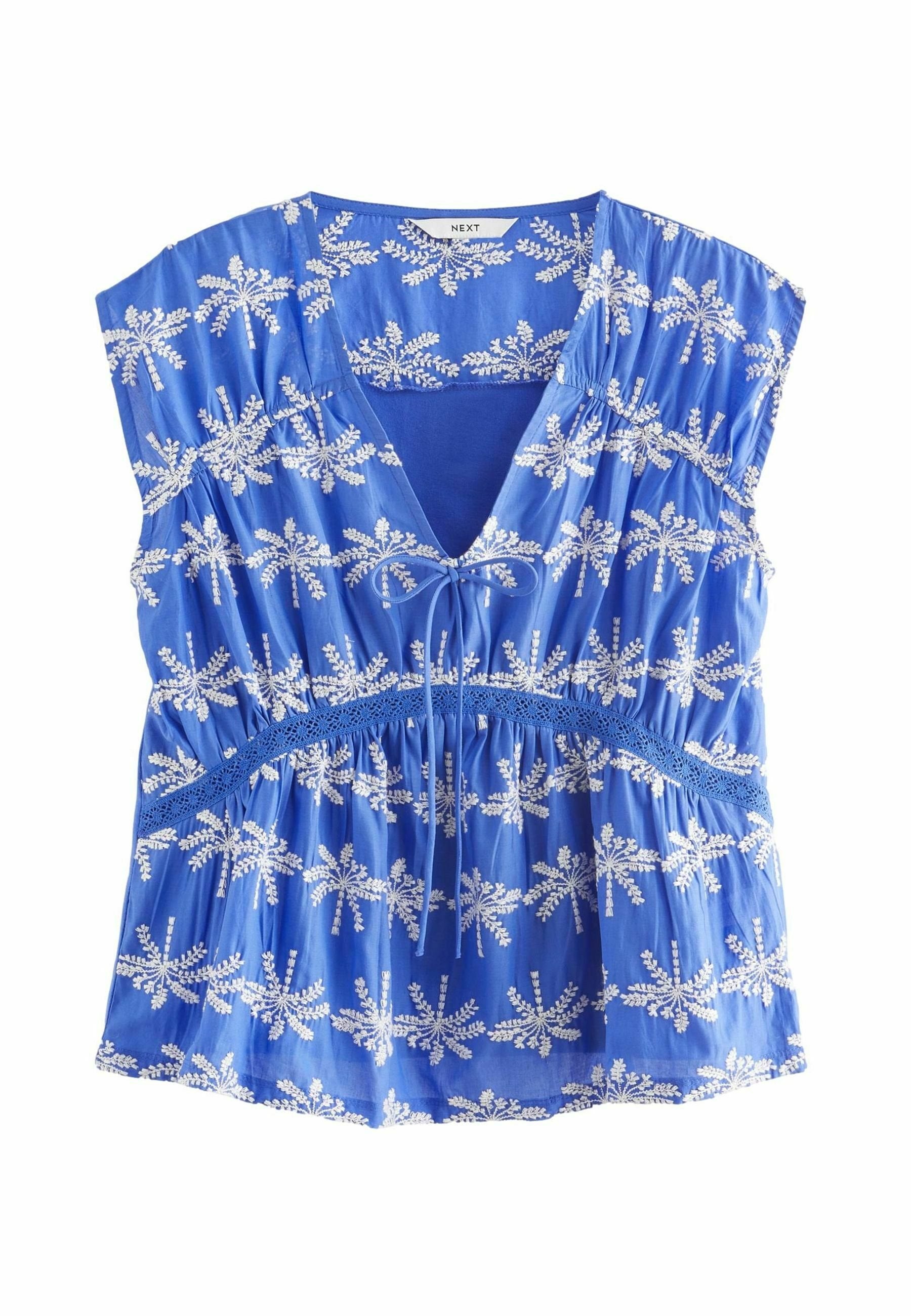Blaue Bluse mit kurzen Ärmeln, V-Ausschnitt, Kordelzug vorne und weißer Blumenstickerei. Leichtes Material mit gerafft Taille und Spitzelementen.