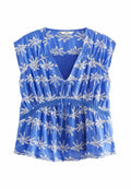 Blaue Bluse mit kurzen Ärmeln, V-Ausschnitt, Kordelzug vorne und weißer Blumenstickerei. Leichtes Material mit gerafft Taille und Spitzelementen.