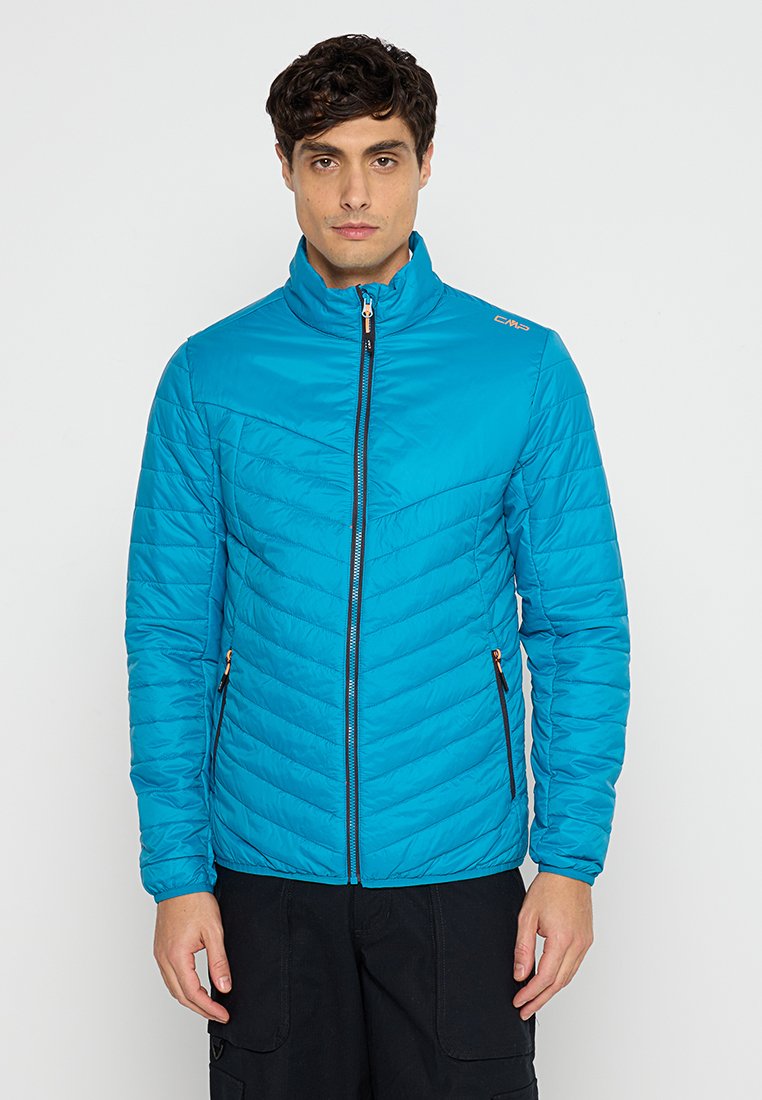 Blaue isolierte Jacke mit hohem Kragen, diagonaler Steppung und Reißverschluss vorne. Mit schwarzem Reißverschluss und zwei Seitentaschen.