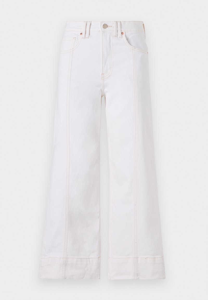 Weiße weit geschnittene Jeans aus Denim, mit sichtbaren Nähten, einem Knopfverschluss und vorderen Taschen. Der Stoff hat eine minimale Struktur.